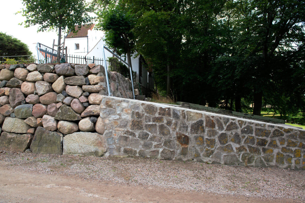 en bruksmur av natursten vid en kyrka