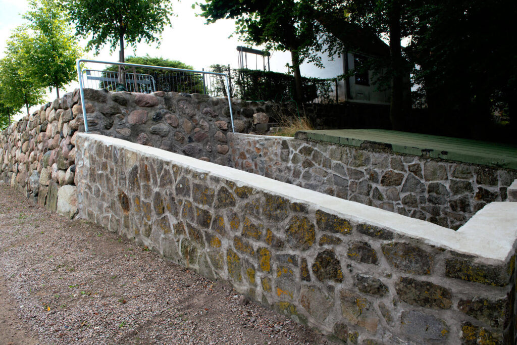 en bruksmur av natursten vid en kyrka