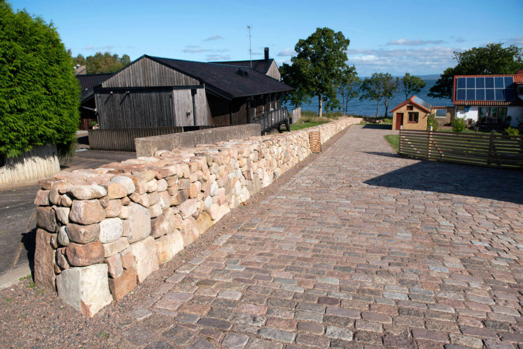 en lång stenmur vid havet