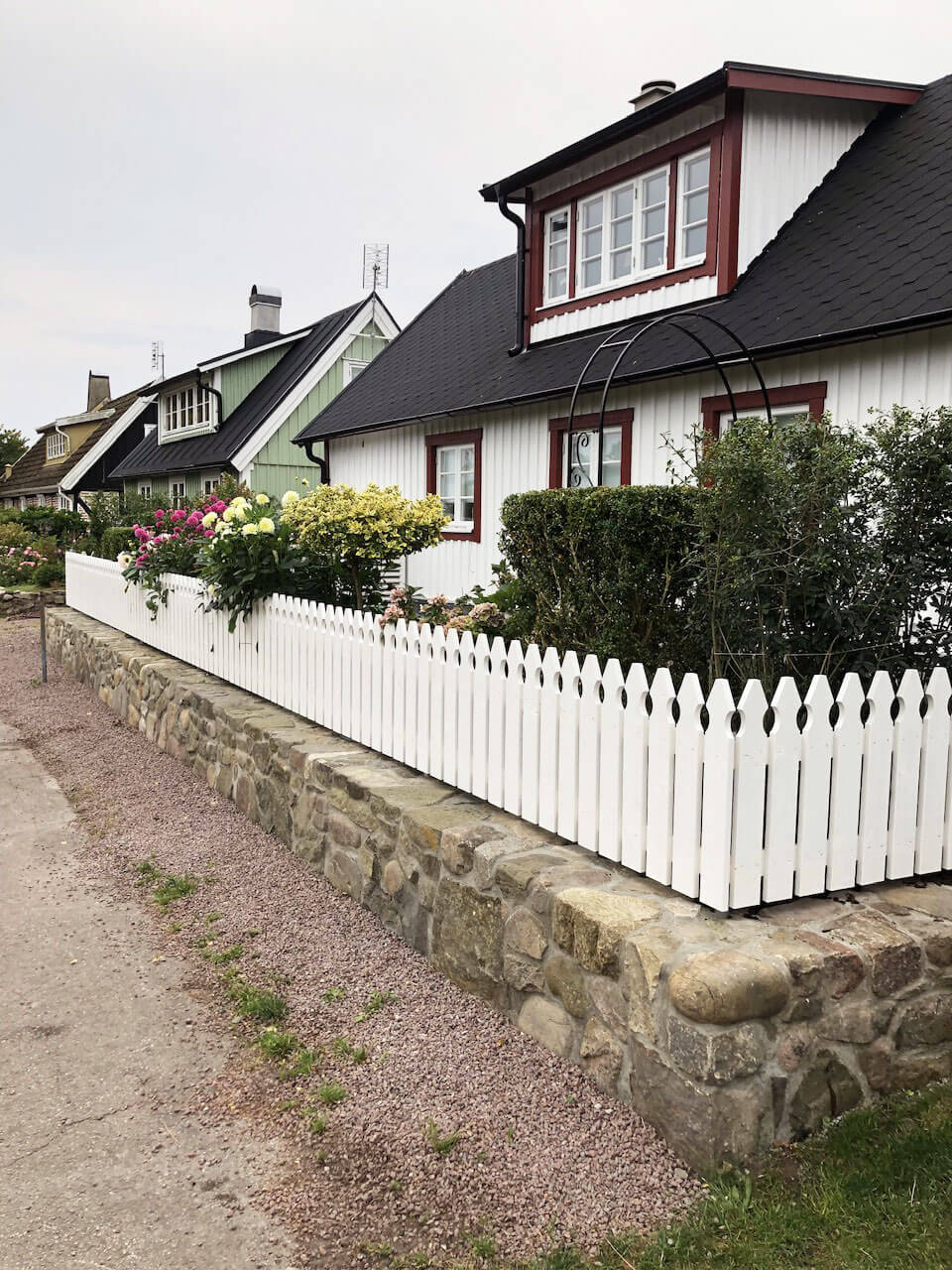 en bruksmur av sprängsten med ett vitt staket ovanpå